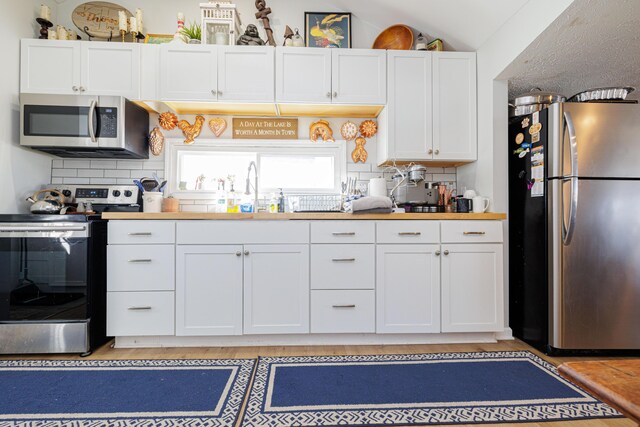 127 Brads Way, Russells Point, OH 43348 - kitchen with appliances with stainless steel finishes, white cabinets, a sink, and decorative backsplash