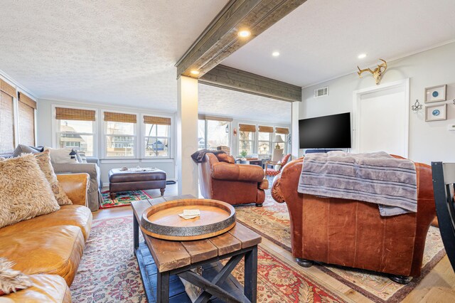 127 Brads Way, Russells Point, OH 43348 - living area featuring light wood finished floors, visible vents, a textured ceiling, and ornamental molding