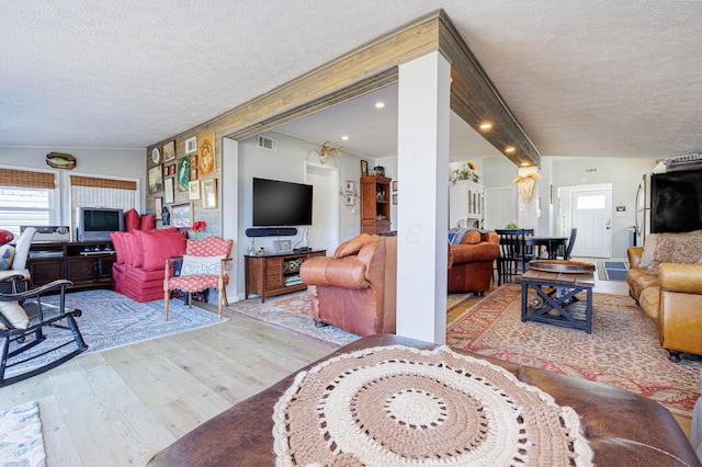 127 Brads Way, Russells Point, OH 43348 - living area featuring visible vents, wood finished floors, a textured ceiling, ornate columns, and recessed lighting