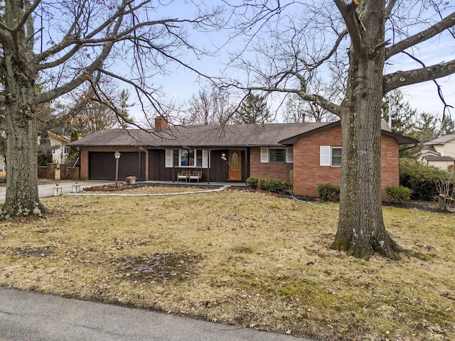 ranch-style home with a garage, driveway, a chimney, and brick siding