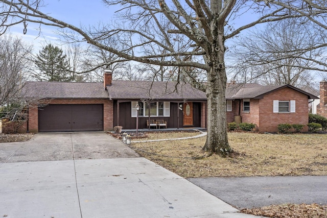 ranch-style home featuring a garage, concrete driveway, brick siding, and a chimney