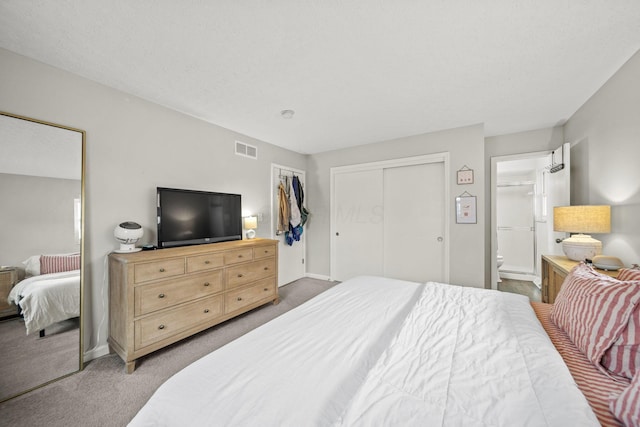 carpeted bedroom with ensuite bathroom, a closet, visible vents, and baseboards