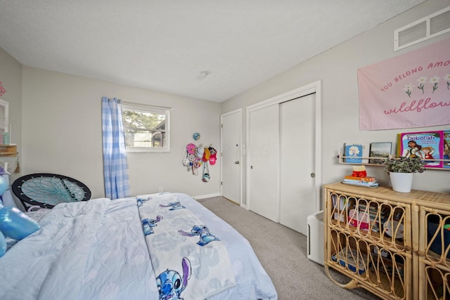 bedroom featuring a textured ceiling, a closet, carpet flooring, and visible vents