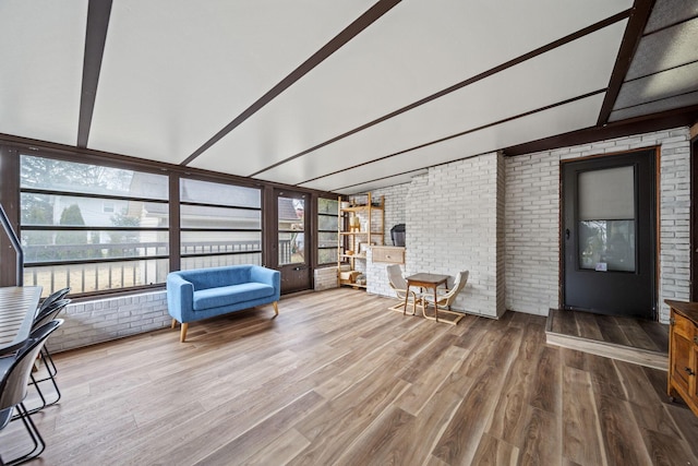 unfurnished sunroom featuring lofted ceiling with beams