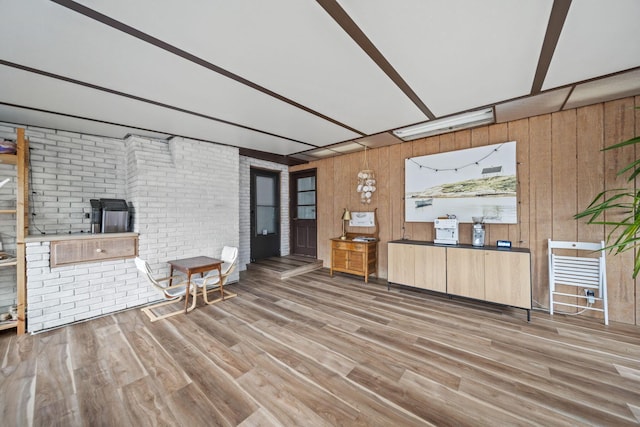 interior space with wood walls, brick wall, and wood finished floors