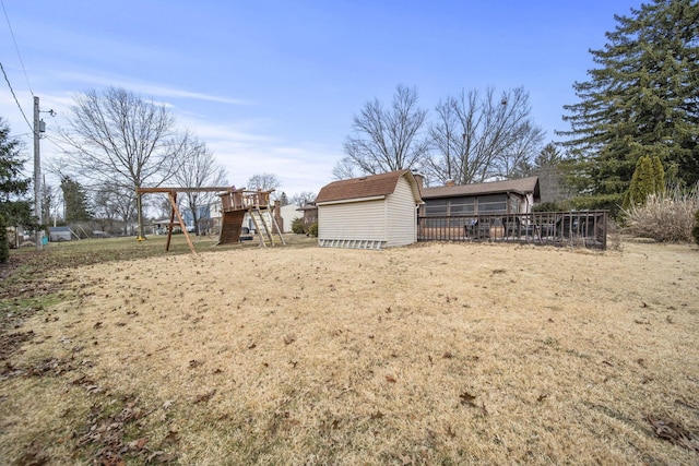 view of yard featuring a storage unit, a playground, and an outbuilding