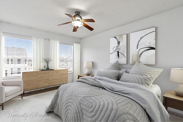 bedroom with a ceiling fan and light carpet