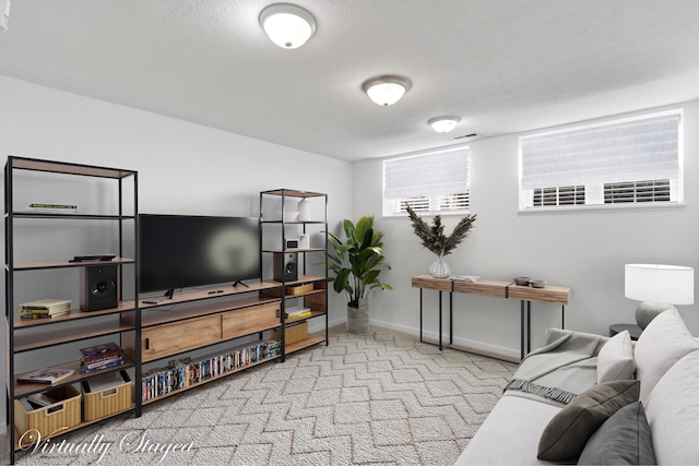 carpeted living area with visible vents, a textured ceiling, and baseboards