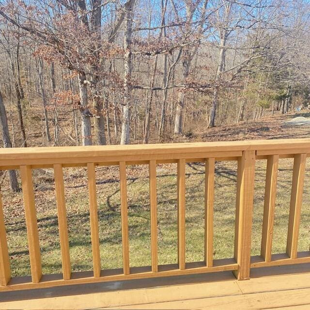 wooden deck with a wooded view