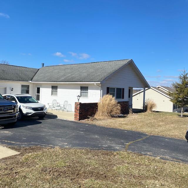 view of front of property featuring aphalt driveway and a shingled roof