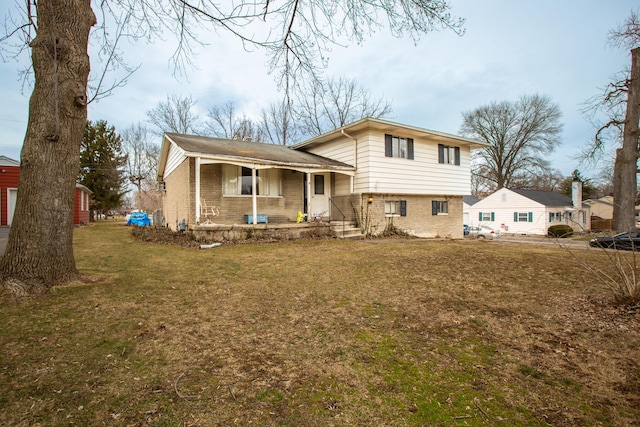 split level home featuring a front yard, a porch, and brick siding