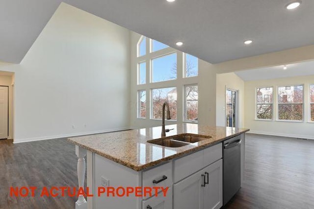 kitchen featuring dark wood-type flooring, a sink, open floor plan, stainless steel dishwasher, and a center island with sink