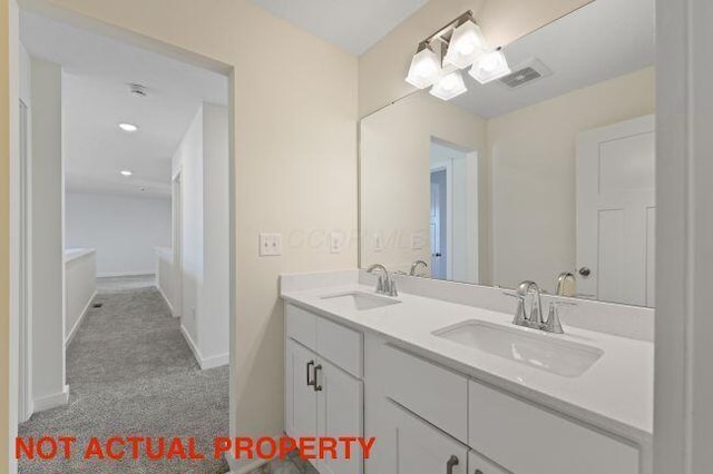 full bathroom featuring visible vents, a sink, baseboards, and double vanity