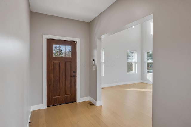 foyer with light wood-style floors and baseboards