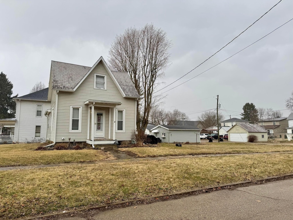 view of front of house with a front yard and a detached garage