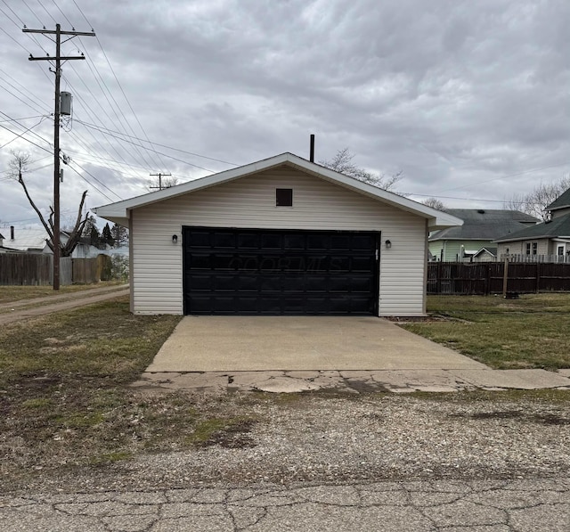 detached garage featuring fence