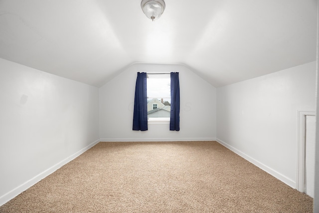 additional living space with vaulted ceiling, carpet, and baseboards