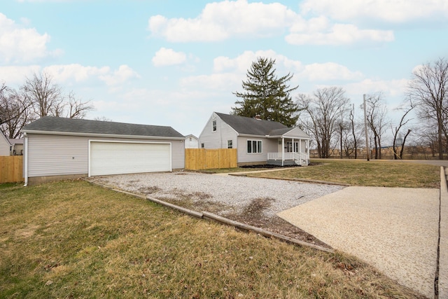 ranch-style home with a garage, a front yard, covered porch, and fence