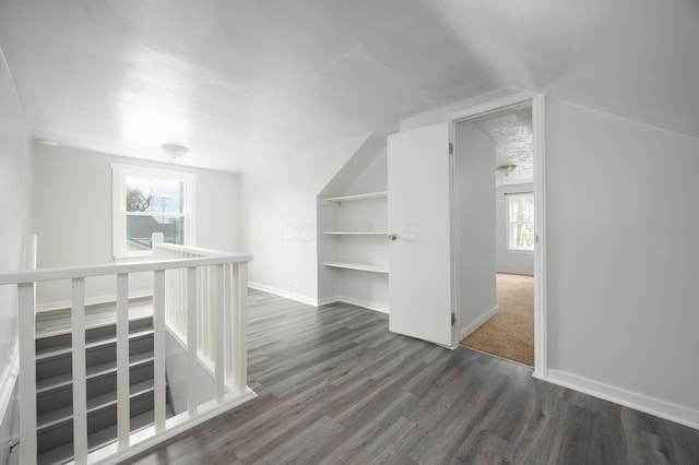 bonus room featuring dark wood-style floors, vaulted ceiling, and baseboards