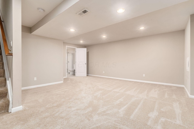 finished basement featuring stairway, recessed lighting, visible vents, and light colored carpet