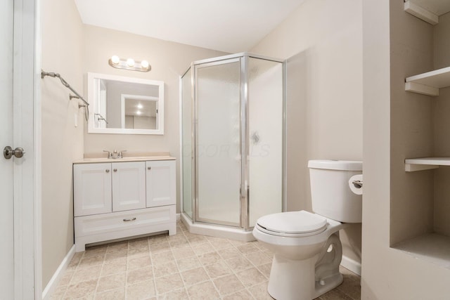 bathroom featuring toilet, a stall shower, baseboards, and vanity