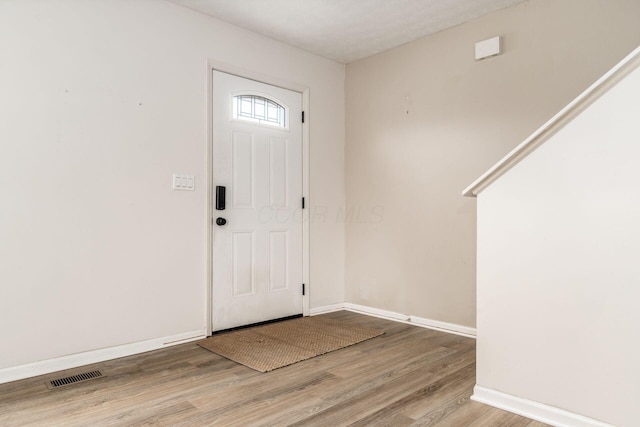 entryway featuring visible vents, baseboards, and wood finished floors