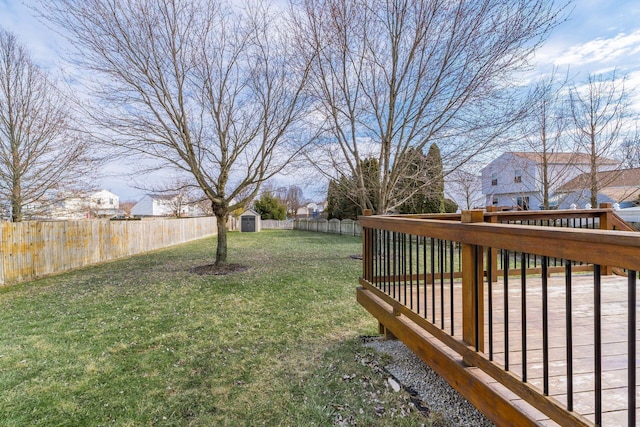 view of yard featuring a fenced backyard, a shed, an outdoor structure, and a wooden deck