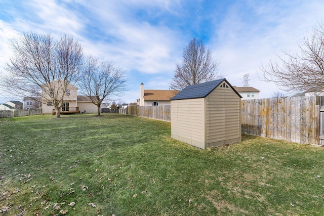 view of yard featuring a fenced backyard, a storage unit, and an outdoor structure