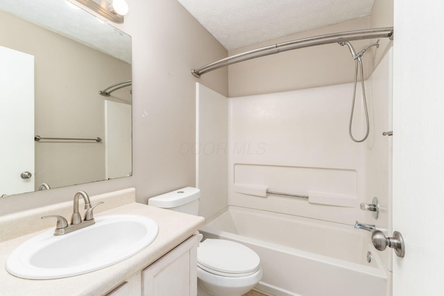 bathroom featuring toilet,  shower combination, a textured ceiling, and vanity