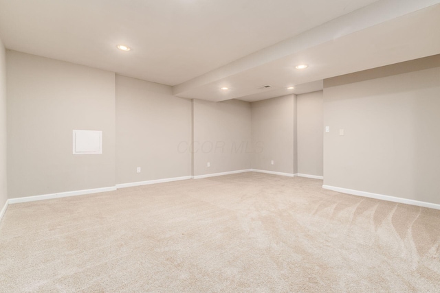 finished below grade area featuring recessed lighting, light carpet, and baseboards