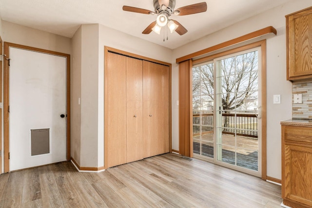 unfurnished bedroom featuring baseboards, a closet, light wood-type flooring, and access to exterior