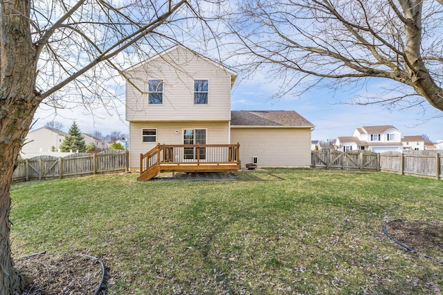 rear view of property featuring a lawn, a fenced backyard, and a wooden deck