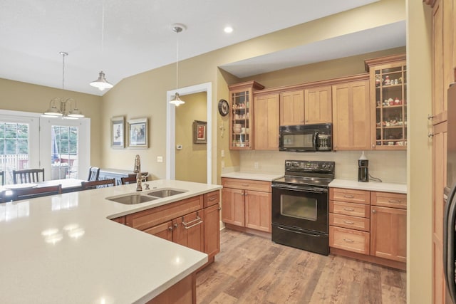 kitchen with black appliances, backsplash, a sink, and light countertops