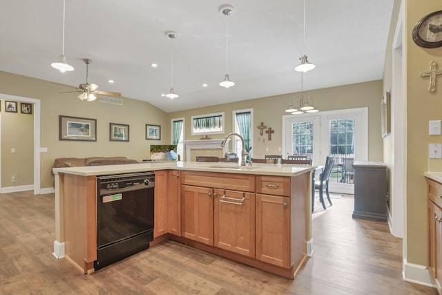 kitchen featuring dishwasher, open floor plan, hanging light fixtures, light countertops, and a sink