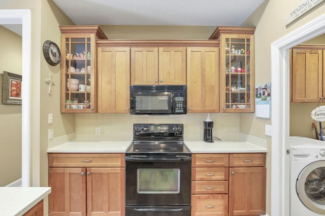 kitchen featuring light countertops, decorative backsplash, glass insert cabinets, washer / dryer, and black appliances