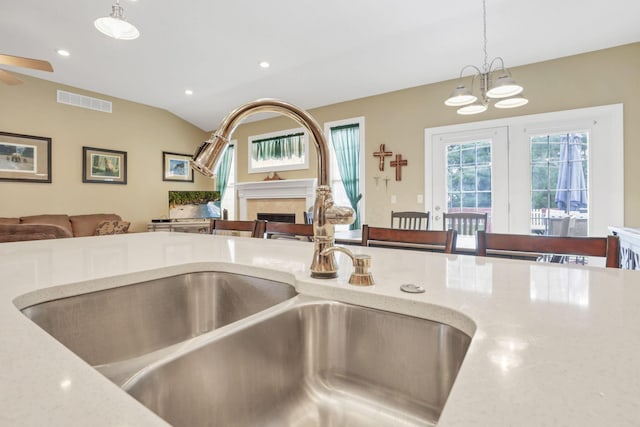 details featuring pendant lighting, a fireplace, recessed lighting, a sink, and ceiling fan with notable chandelier