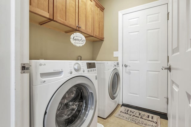 washroom with light tile patterned floors, independent washer and dryer, and cabinet space