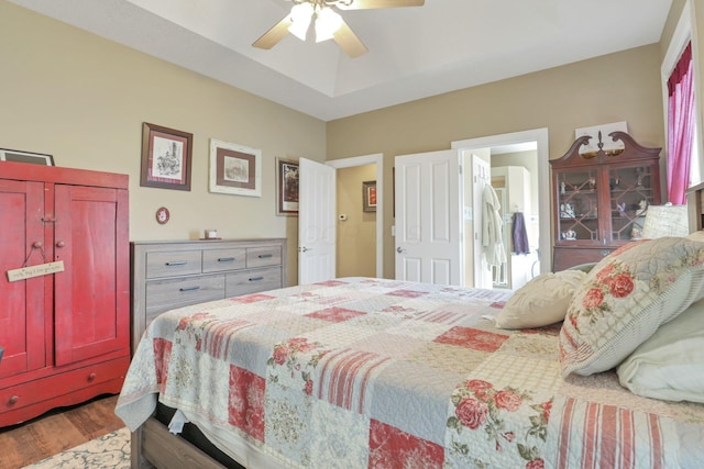 bedroom featuring ceiling fan, a tray ceiling, and wood finished floors