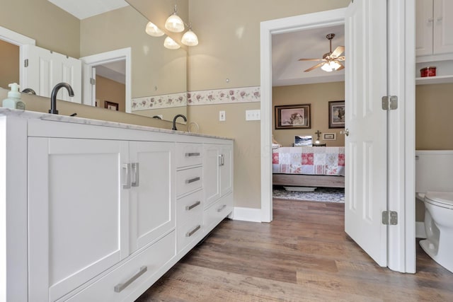 bathroom featuring toilet, ensuite bath, ceiling fan, wood finished floors, and vanity