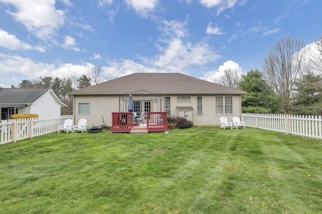 back of property with a fenced backyard, a lawn, and a wooden deck