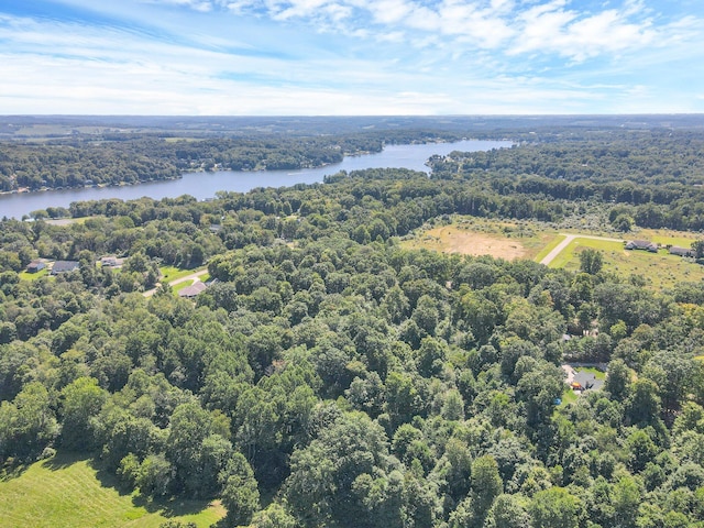 drone / aerial view featuring a water view and a wooded view