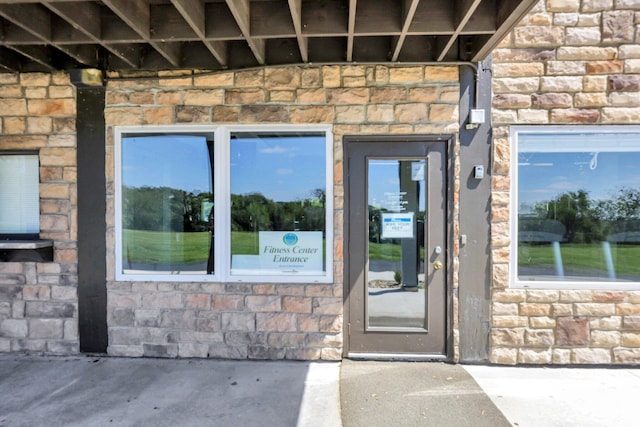 view of exterior entry featuring stone siding