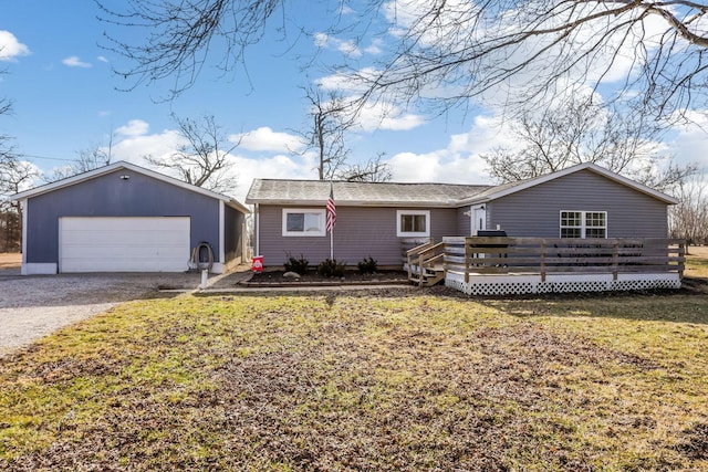 single story home featuring a garage, an outbuilding, a deck, and a front lawn