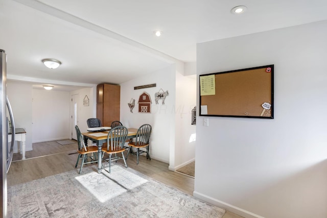 dining room featuring wood finished floors, baseboards, and stairs