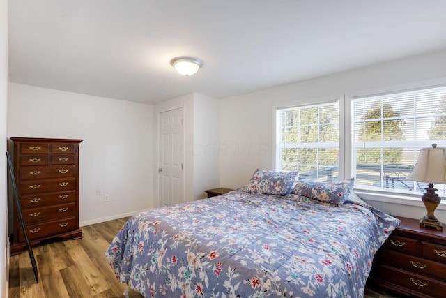 bedroom with wood finished floors and baseboards