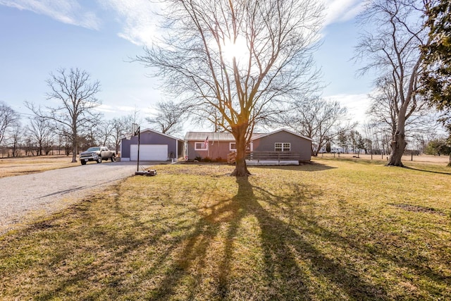 view of front of property with a garage, an outdoor structure, and a front yard