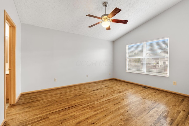 unfurnished room with light wood-style flooring, vaulted ceiling, a textured ceiling, ceiling fan, and baseboards