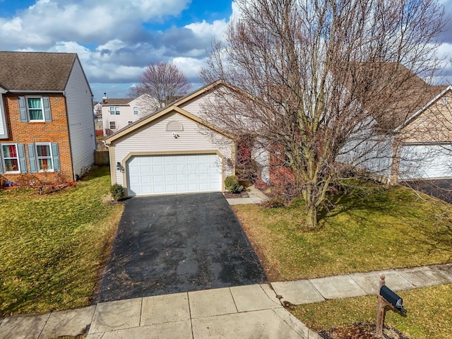 view of front of property featuring aphalt driveway, a garage, and a front lawn