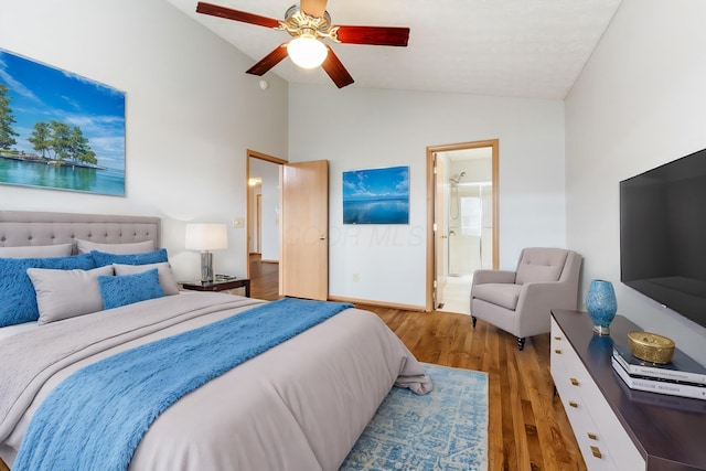 bedroom with lofted ceiling, ceiling fan, ensuite bath, and wood finished floors