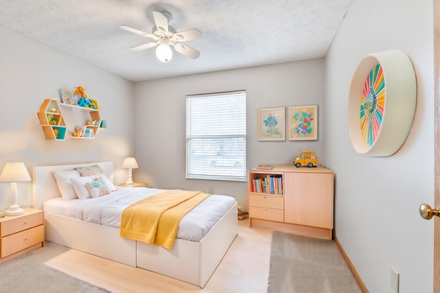 bedroom featuring ceiling fan, baseboards, and a textured ceiling